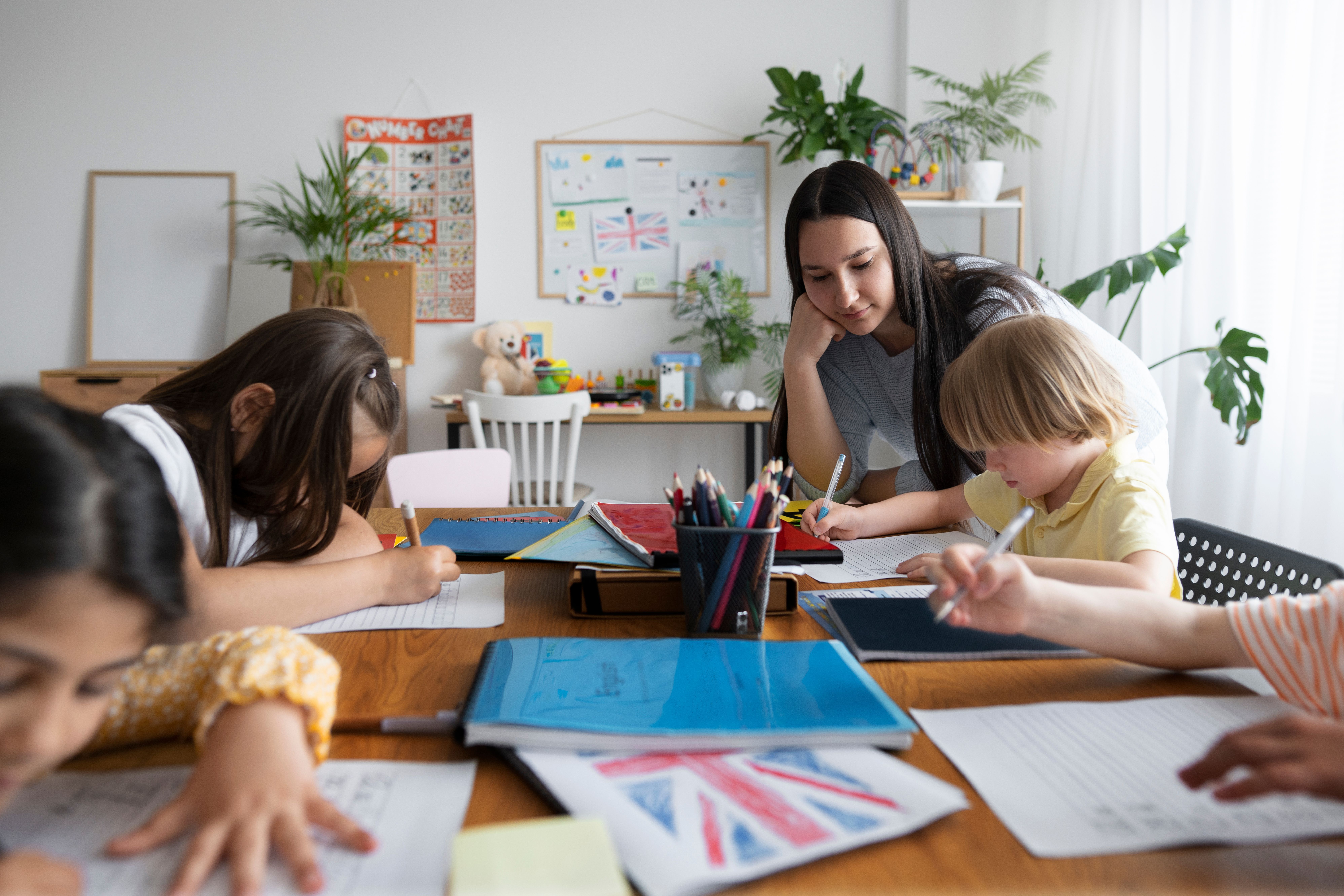 Maestra enseñando inglés a niños con materiales didácticos